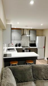 a living room with a couch and a kitchen at Abbey House in Horsham