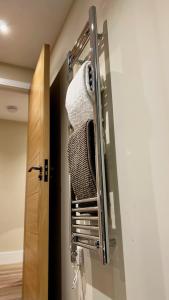 a bathroom with a towel rack next to a door at Abbey House in Horsham