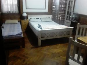 1 dormitorio con 2 camas y suelo de madera en Habitac Indiv Casa de Familia, Flores en Buenos Aires