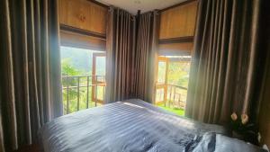 una camera da letto con un letto e una grande finestra di Sapa Garden Bungalow a Sa Pa