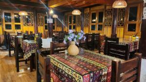 un restaurante con una mesa con un jarrón de flores. en Sapa Garden Bungalow en Sa Pa