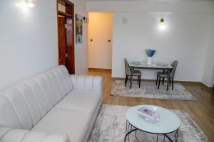 a living room with a white couch and a table at Sana Home by Edmor Suites in Nairobi