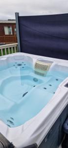 a jacuzzi tub sitting on top of a porch at Bill's Retreat - Lodge & Hot tub in Morpeth