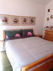 a bedroom with a large bed with pink pillows at Appartamento - Pila Ciel Bleu - Il balcone sulle Alpi in Pila
