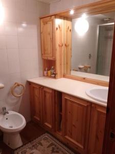 a bathroom with a sink and a toilet and a mirror at Appartamento - Pila Ciel Bleu - Il balcone sulle Alpi in Pila