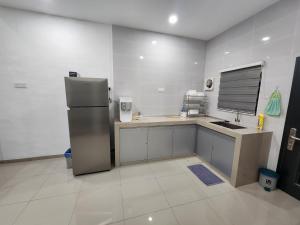 a kitchen with a refrigerator and a sink at Voon 4 bedroom homestay Mersing 2 in Mersing