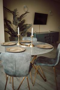 a table with two candles on top of it with chairs at Apartament Ploiesti Central in Ploieşti