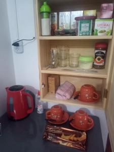 a kitchen counter with a cupboard filled with food at Hostal Tía Dora in San Salvador de Jujuy