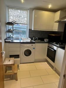a kitchen with a sink and a washing machine at Specious apartment In Canning Town ( London ) in London