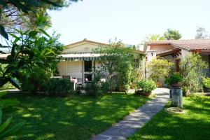 uma casa com um jardim verde com um caminho em casaisoladelba em Lacona