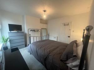 a bedroom with a bed and a dresser and a television at Sleeps up to 8 Free Parking Large Town House 3 Bed, 2 Bathrooms Private Locked Garden In-between Nottingham & Derby Contractor Friendly in Ilkeston