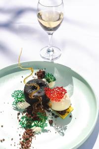 a plate of food on a table with a glass of wine at Zanzibar Queen Hotel in Matemwe
