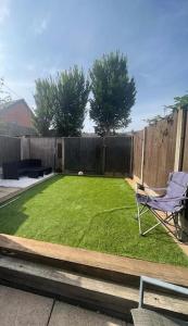 a yard with a chair and a fence at Large 3 Bed House, 2 Bathrooms in Ilkeston