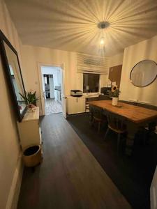 a kitchen and dining room with a wooden table at Sleeps up to 8 Free Parking Large Town House 3 Bed, 2 Bathrooms Private Locked Garden In-between Nottingham & Derby Contractor Friendly in Ilkeston