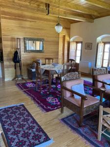 d'une salle à manger avec une table, des chaises et des murs en bois. dans l'établissement Παραδοσιακή Κατοικία στο Μαίναλο, à Alonistaina