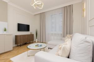 un soggiorno bianco con divano bianco e TV di Bright & Elegant Apartment Warsaw by Renters a Varsavia