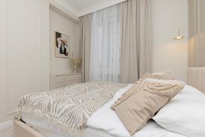 una camera da letto bianca con un letto a motivi zebrati di Bright & Elegant Apartment Warsaw by Renters a Varsavia