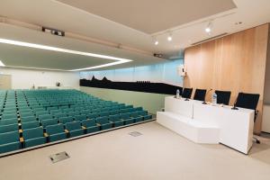 an empty lecture hall with blue chairs and a podium at FIAP Paris in Paris