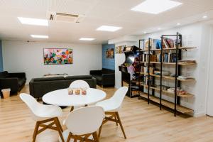 Una sala de estar con una mesa y sillas y un sofá. en FIAP Paris, en París