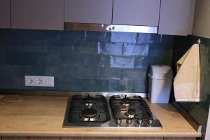 cocina con fogones y azulejos azules en Downtown Apartment en Kutaisi