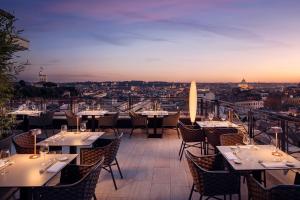 a restaurant with tables and chairs with a view of the city at Sina Bernini Bristol, Autograph Collection in Rome