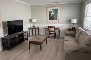 uma sala de estar com um sofá e uma televisão de ecrã plano em Marco Island Lakeside Inn em Marco Island