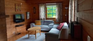 ein Wohnzimmer mit einem Sofa und einem Tisch in der Unterkunft Tassutupa in Hulmi