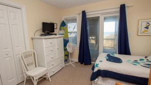 a bedroom with a bed and a tv and a window at OCEANFRONT, Ocean Views, ELEVATOR, Private Beach Walkway, BB14, Heart Of Duck in Duck