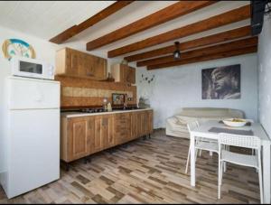 een keuken met een koelkast en een tafel en een bed bij Neptuno OceanFront in Telde