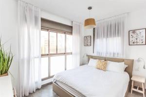 ein weißes Schlafzimmer mit einem Bett und einem Fenster in der Unterkunft 3Bedroom Suite with balcony Yona Hotel in Tel Aviv