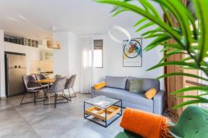 ein Wohnzimmer mit einem Sofa und einem Tisch in der Unterkunft 3Bedroom Suite with balcony Yona Hotel in Tel Aviv