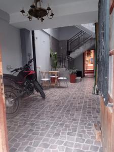 una moto parcheggiata in una stanza con tavolo di Hostal Tia Dora a San Salvador de Jujuy