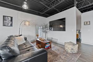 a living room with a leather couch and a table at The 418. An 1866 Build with Modern Comforts in Fort Wayne