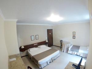 Spazio Vital Apartments في فلوريانوبوليس: غرفة فندقية بسريرين وطاولة