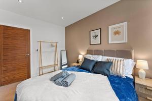 a bedroom with a large bed with blue pillows at Modern Luxe Living in Lincoln - Flat 3 in Lincolnshire