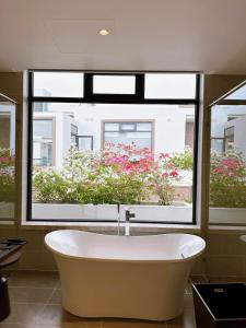 uma banheira na casa de banho com uma grande janela em Phoenix Pool Villa Cam Ranh em Cam Ranh