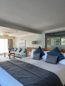 a bedroom with a large bed with blue pillows at De Vere Cotswold Water Park in Cirencester