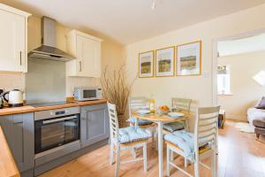 a kitchen and dining room with a table and chairs at Hearts Delight Cottage by Bloom Stays in Bridge