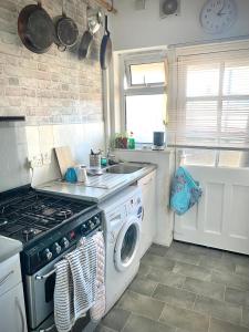 a kitchen with a stove and a washing machine at Room in apartment home-Stretford in Manchester