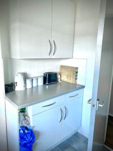 a kitchen with white cabinets and a counter top at Room in apartment home-Stretford in Manchester