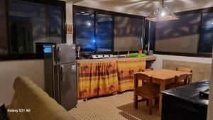 eine Küche mit einem Kühlschrank und einem Tisch mit Stühlen in der Unterkunft Villa Les Pieux in Somone
