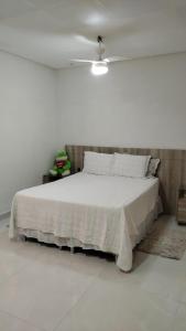 Cama blanca en habitación blanca con techo en Casa 108 en Guaibim