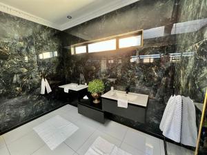 a bathroom with two sinks and a black wall at Forty 4 On Hoog in Polokwane