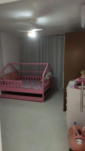 ein Schlafzimmer mit einem rosa Bett in einem Zimmer in der Unterkunft Casa 108 in Guaibim