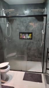 a shower stall with a toilet in a bathroom at Casa 108 in Guaibim
