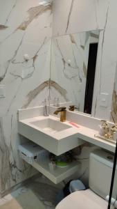 a bathroom with a white sink and a mirror at Casa 108 in Guaibim