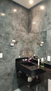 a bathroom with a black sink and a mirror at Casa 108 in Guaibim