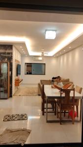 a person sitting at a table in a living room at Casa 108 in Guaibim