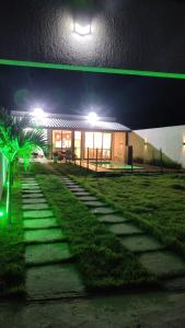 a building at night with green lights on it at Casa 108 in Guaibim