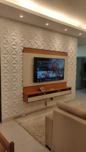 a flat screen tv on a wall in a living room at Casa 108 in Guaibim